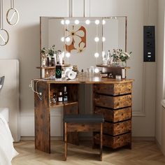 a bedroom with a vanity, mirror and lights on it's side table in front of a bed