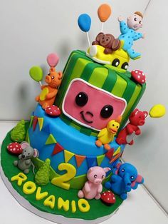 a birthday cake decorated with animals and balloons