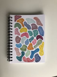 a spiral notebook with colorful hearts drawn on it