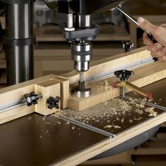 a person using a milling machine to cut wood