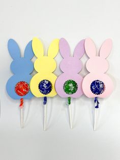 three lollipop sticks with easter bunnies on them in the shape of bunny ears