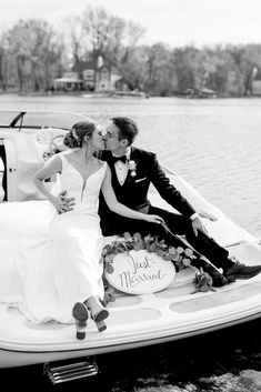 a bride and groom are kissing on a speed boat in the water at their wedding