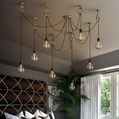 a chandelier hanging from the ceiling in a room with white curtains and windows