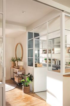 an open kitchen and living room with plants in the window sill on the far wall