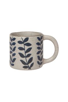 a white and blue mug with leaves on it