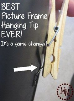 a pair of scissors being held up to the side of a black board with text that reads best picture frame hanging tip ever it's a game changer