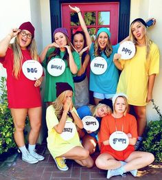 a group of women standing next to each other in front of a door holding up signs