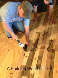 two men working on wood flooring in a house