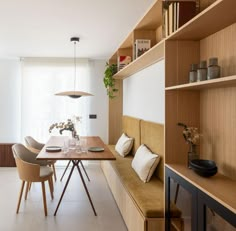 a dining room table and chairs in front of a bookshelf