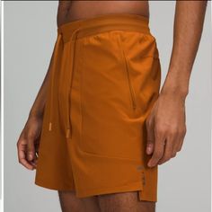 Men’s License To Train Shorts Length 7” Sweat Wick For More Comfort Waistband Drawcord Secure Zip Pockets Classic Tapered Fit Orange Athleisure Activewear With Built-in Shorts, Orange Sports Shorts With Pockets, Orange Workout Shorts With Pockets, Orange Athletic Shorts With Elastic Waistband For Sports, Moisture-wicking Orange Shorts For Gym, Orange Moisture-wicking Athletic Shorts For Training, Orange Activewear With Built-in Shorts For Training, Moisture-wicking Orange Gym Shorts, Orange Moisture-wicking Shorts Activewear