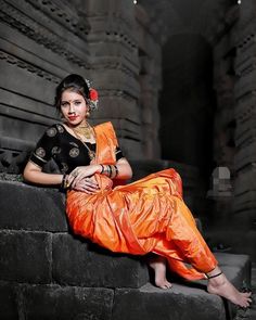 a woman sitting on top of a stone wall