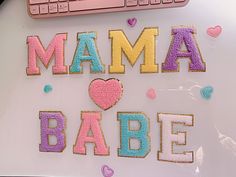 the word mamma babe spelled out with cookies on top of a desk next to a keyboard