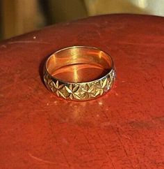 a gold ring sitting on top of a red table