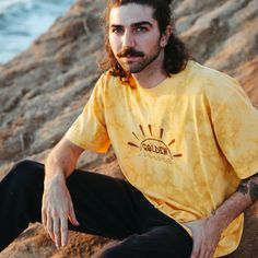 Feel the magic of golden hour whenever you rock this tee! Inspired by sunsets on our California coastline, this t-shirt reflects the sparkling colors of golden hour on the ocean. Our original "Golden" graphic is hand printed on the chest, and our retro logo is printed on the sleeve. Made with recycled cotton fabric by our team in Los Angeles. Gold T-shirt With Letter Print For Summer, Gold Casual T-shirt With Screen Print, Casual Gold T-shirt With Screen Print, Casual Gold T-shirt For Summer, California Coastline, On The Ocean, Retro Logo, You Rock, Golden Hour