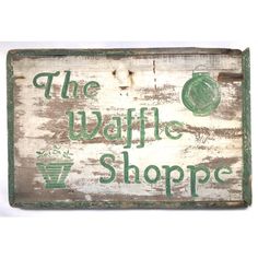 an old wooden sign with the words the waffle shoppe written in green on it