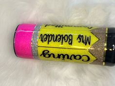 a pink and yellow tube with writing on it sitting on top of a white rug