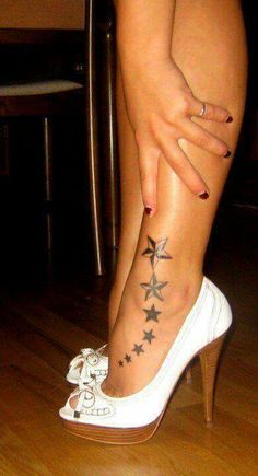 a woman's foot with stars tattooed on it