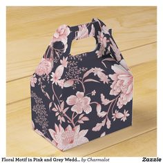 a black and pink flowered bag sitting on top of a wooden floor