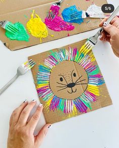 someone is painting a lion on cardboard with crayons