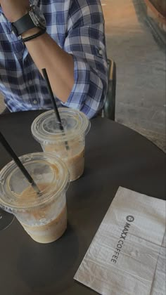 two iced coffees sitting on top of a table