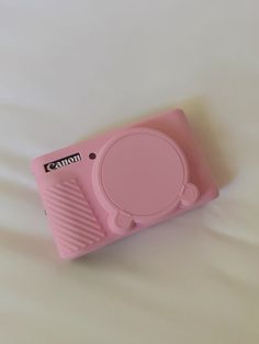 a pink camera sitting on top of a bed