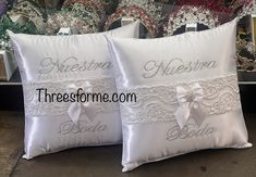 two white pillows with the names of bride and groom on them, sitting next to each other