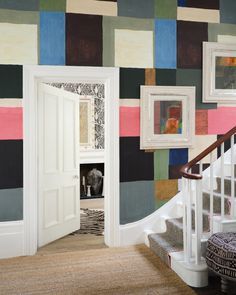 an entry way with colorful wallpaper on the walls and stairs leading to another room