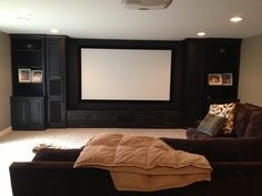 an image of a large room with a projector screen and couches in it