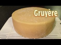 a large round cake sitting on top of a cooling rack with the word gruyere written above it