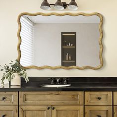 a bathroom vanity with a large mirror above it