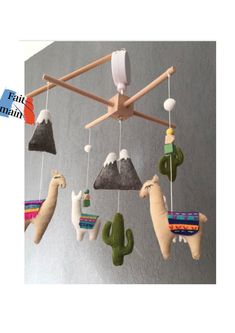 a mobile with llamas and cactuses hanging from it