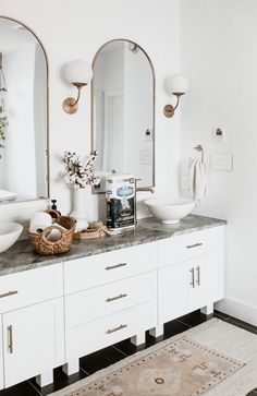 a bathroom vanity with two sinks and mirrors