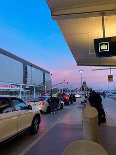 cars are parked on the side of the road in front of a building at dusk