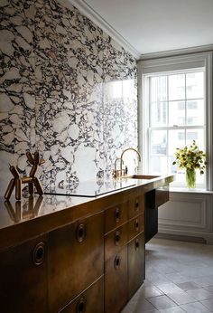 a kitchen with marble counter tops and an island in front of a window that has flowers on it