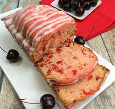 a loaf of cake on a plate with cherries