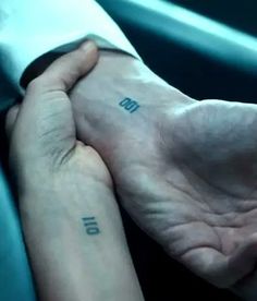 two hands holding each other with the word love tattooed on them