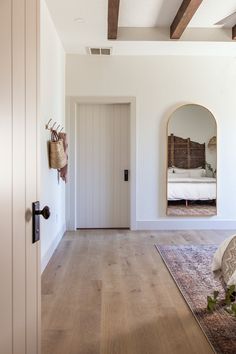 an empty room with white walls and wood flooring is seen through the door to another room