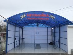 an empty garage with a blue awning over it