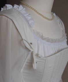 For the 18th century silhouette, I propose a corset to wear on your day shirt. An essential element of any outfit of the 18th century, this corset is made in 2 versions: - Cotton striped white and blue, lined in white cotton. - Cotton white, lined in white cotton White lacing link. Like any corset of the ladies of the bourgeoisie or of the nobility, it is laced only in the back. The servants and peasants only, wore corsets laced at the front, for they had no one to help them dress. Knotted at th Elegant Historical Design Corset For Costume Party, Elegant White Square Neck Corset, Elegant Corset With Historical Design For Costume Party, Victorian White Underbust Corset, White Underbust Corset For Costume, White Underbust Gothic Corset, White Victorian Overbust Corset, Regency Style Overbust Corset With Historical Design, Wedding Regency Style Underbust Corset