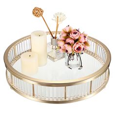 a table with flowers and candles on it, including two votive candle holders in the center