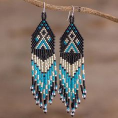 two pairs of beaded earrings hanging from a branch