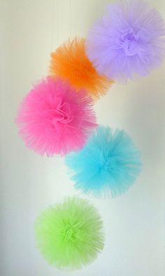 four different colored tulle balls hanging from the ceiling