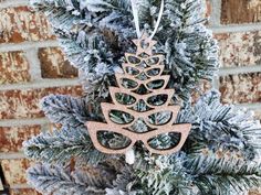 a christmas ornament hanging from the side of a tree with glasses on it