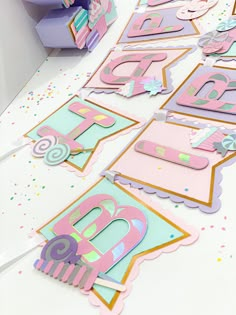 a table topped with lots of pink and blue paper cut out letters on top of it