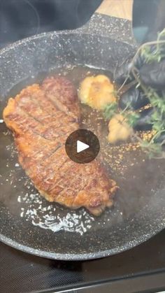 steak being cooked in a skillet on top of a stove with other food items