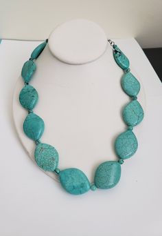 "Gorgeous turquoise dyed howlite necklace featuring larger rounded diamond shaped beads interspersed with small round beads. The silver tone extension chain with the lobster claw closure allows the length to be shortened by up to 3\" if desired.  The total length is 21\". The larger beads are 1 1/2\" by 1\". The smaller beads have a diameter of 3/16\". Condition: Previously owned. In very good vintage condition. Please do see the photos as they are part of the description.  Please do browse our other items as we do combine shipping for added savings." Adjustable Polished Turquoise Bead Necklace, Beaded Howlite Turquoise Necklace With Round Beads, Turquoise Howlite Necklace With Round Gemstone Beads, Adjustable Turquoise Stone Necklace, Adjustable Turquoise Stone Necklaces, Turquoise Howlite Necklace With Natural Stones, Beaded Turquoise Howlite Necklace, Adjustable Turquoise Jewelry With Large Beads, Beaded Howlite Necklaces With Round Beads