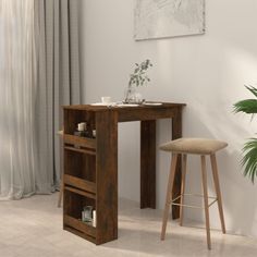 a wooden desk with two stools next to it and a plant in the corner