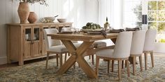 a dining room table and chairs in front of a window