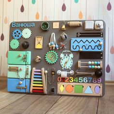 an assortment of different items on a wooden table with wallpaper in the background and hanging from hooks