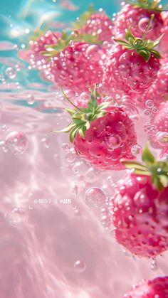 some pink strawberries floating in water with bubbles